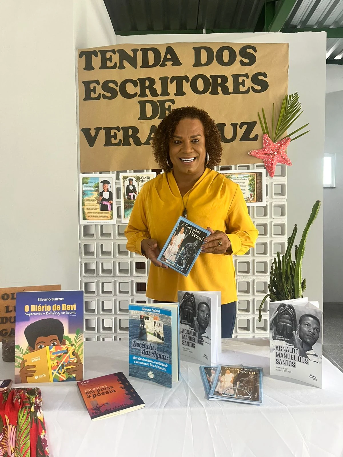 Gil Lima com o livro A Caça Não é Presa durante encontro literário em Vera Cruz