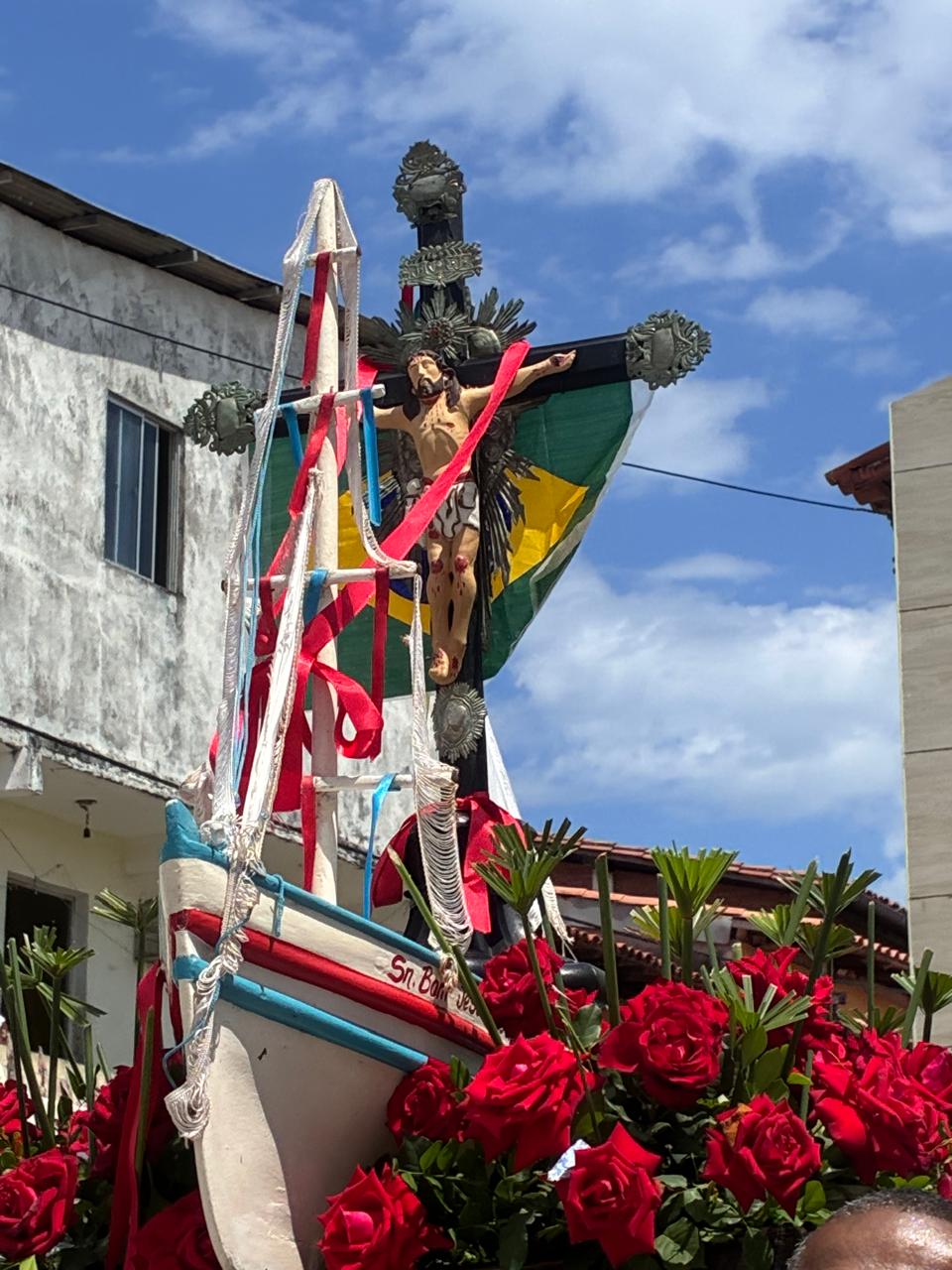 Imagem de Bom Jesus em embarcação decorada com flores durante celebração na Gamboa