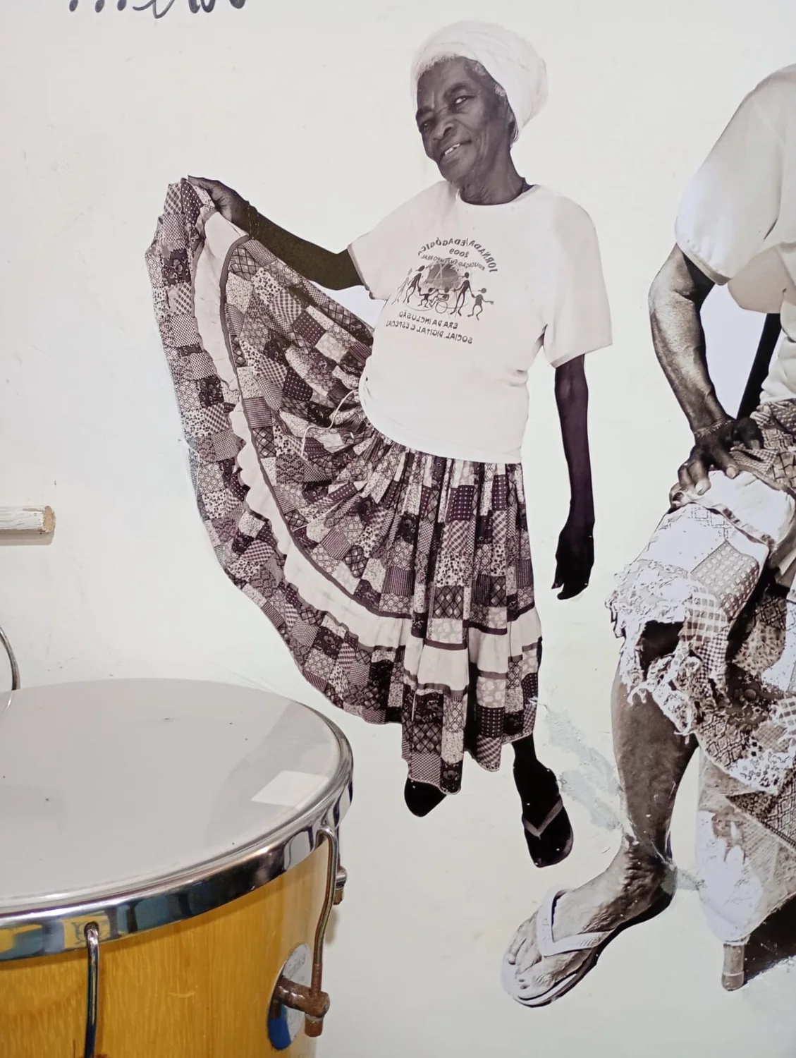 Fotografia antiga de uma mulher com saia rodada exposta no espaço cultural do Quilombo