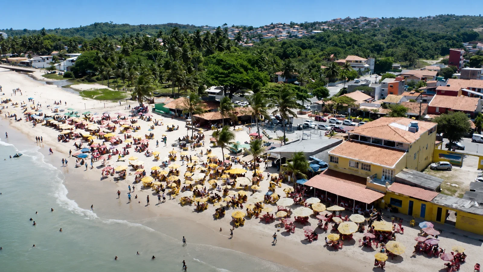 Praia movimentada e comunidade de Mar Grande vista do alto